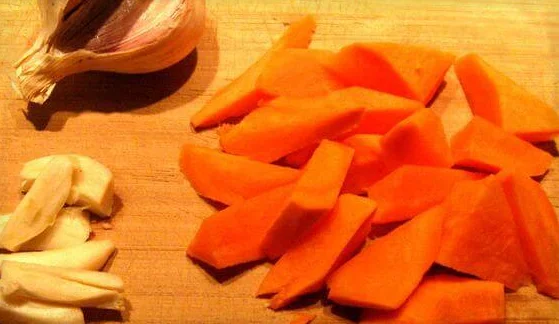 Морковь нарезать остроугольными кусочками длиной 2-3 см., каждый зубчик чеснока разделить на 4 части.