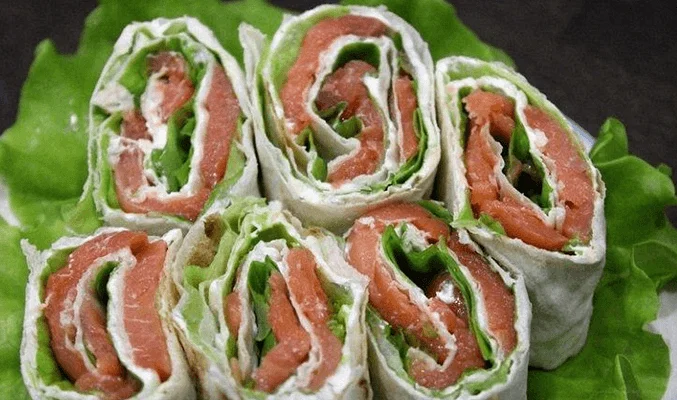 Рулет из лаваша с сыром, красной рыбой и листьями салата