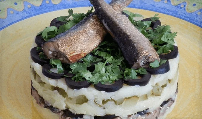 Слоеный салат со шпротами, солеными огурцами, маслинами и картофелем